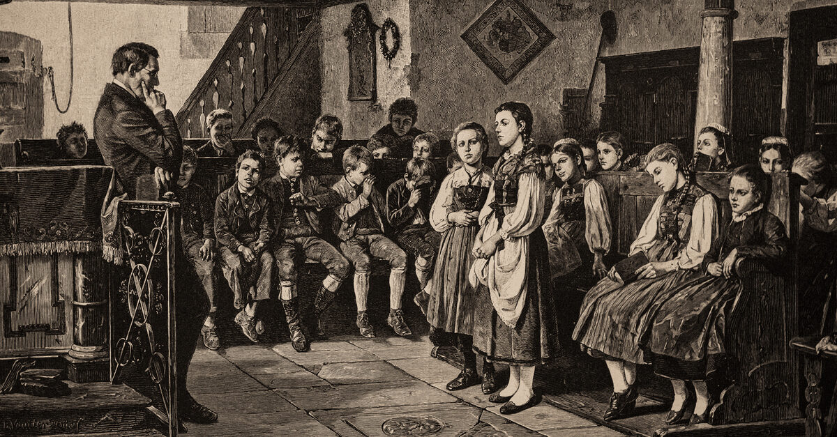 Picture of classroom from around the same time as the first Blaine amendment proposal. Boys sit on one side while girls recite to their teacher in the front.